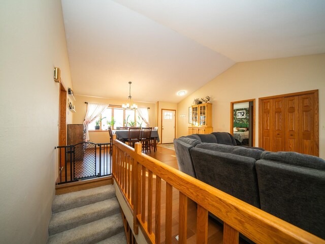 living room with hardwood / wood-style floors, a chandelier, and lofted ceiling