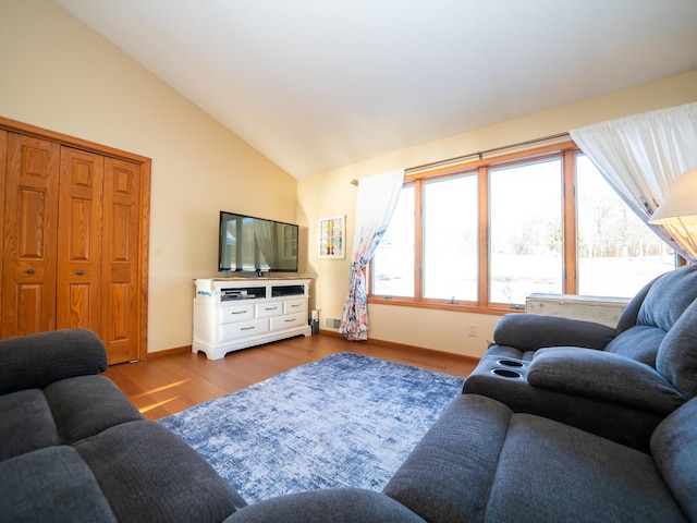 living room featuring light hardwood / wood-style floors and vaulted ceiling