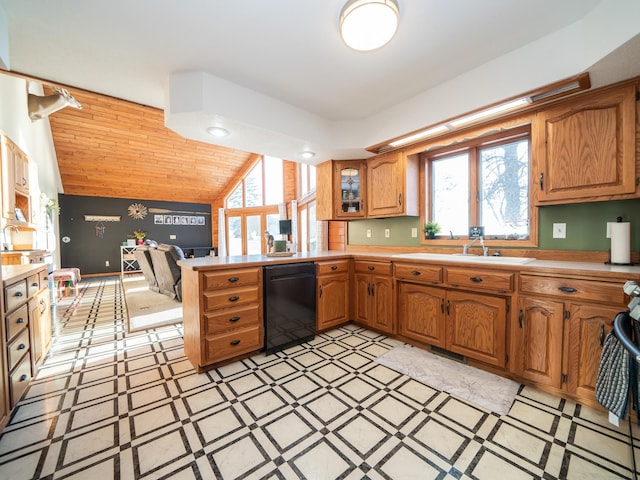 kitchen featuring kitchen peninsula, a healthy amount of sunlight, lofted ceiling, and sink