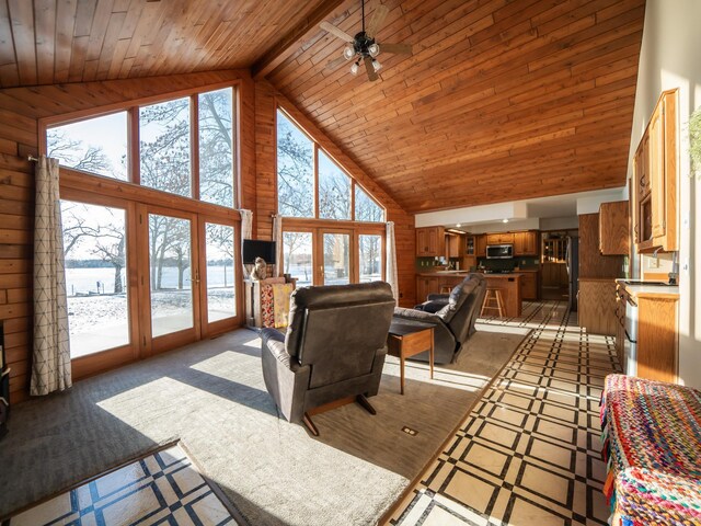 living room with wood ceiling, ceiling fan, wooden walls, high vaulted ceiling, and beamed ceiling