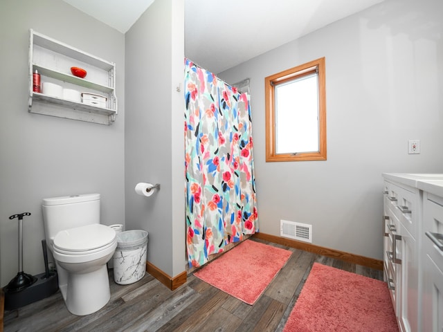 bathroom featuring a shower with curtain, vanity, hardwood / wood-style flooring, and toilet