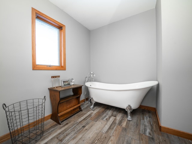 bathroom with a bath and wood-type flooring