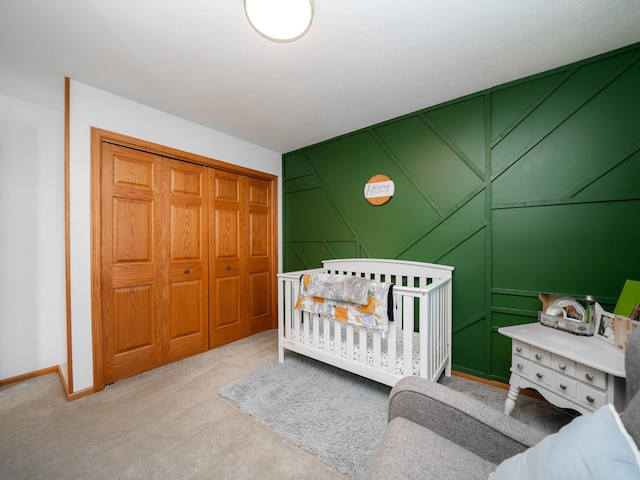 carpeted bedroom with a nursery area and a closet