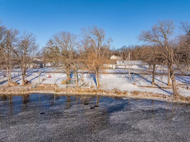 yard covered in snow featuring a water view