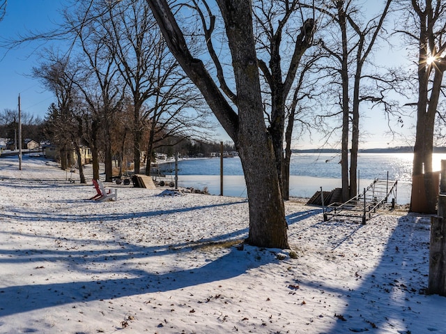 yard covered in snow with a water view