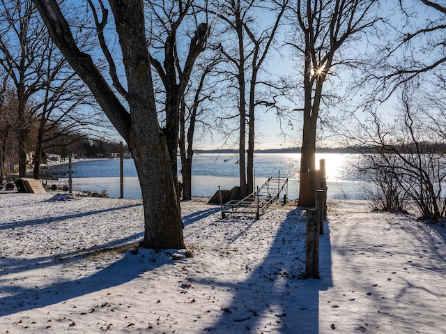 yard covered in snow with a water view