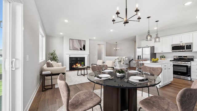 dining space with wood-type flooring and an inviting chandelier