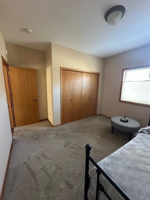 carpeted bedroom featuring a closet and a textured ceiling