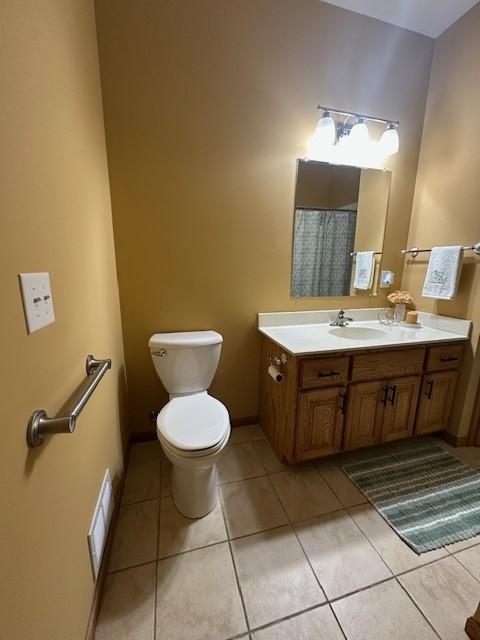 bathroom with tile patterned flooring, vanity, and toilet