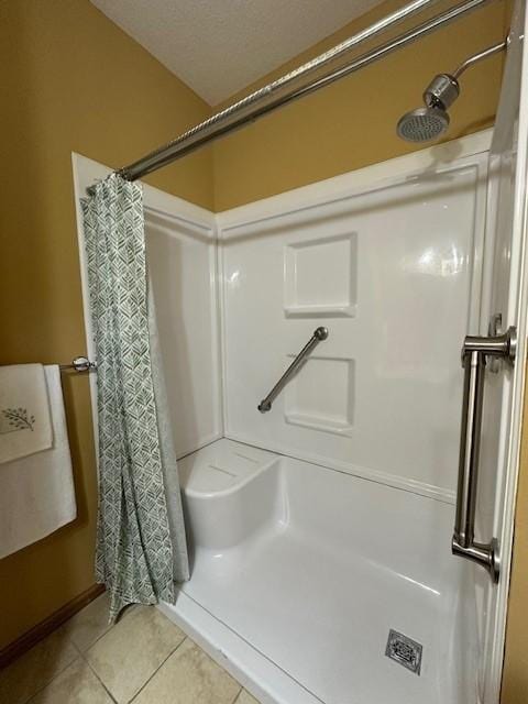 bathroom with tile patterned flooring, a textured ceiling, and walk in shower