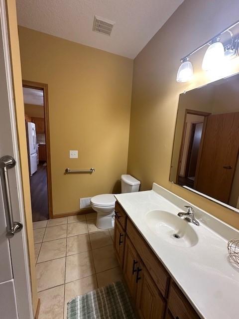 bathroom with tile patterned flooring, vanity, and toilet