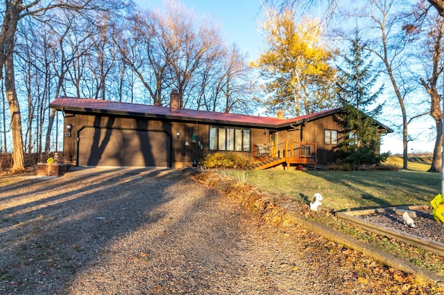 ranch-style house featuring a garage and a front lawn