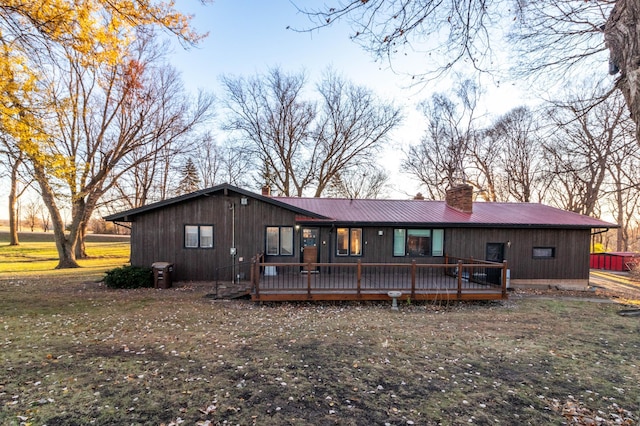 rear view of house featuring a lawn and a wooden deck