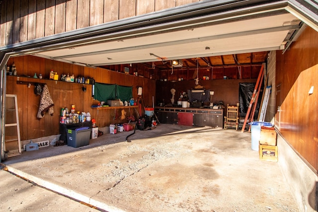 garage with a workshop area and wooden walls