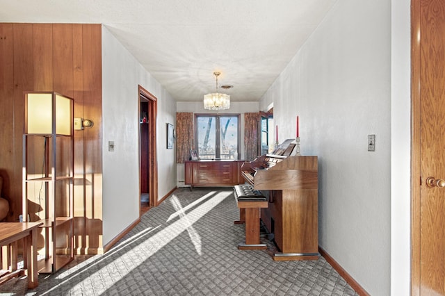 hallway with carpet floors and a chandelier