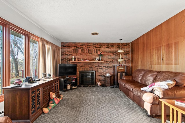 carpeted living room featuring a baseboard radiator, a brick fireplace, brick wall, a textured ceiling, and wooden walls