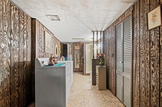 washroom with wooden walls and washer / dryer