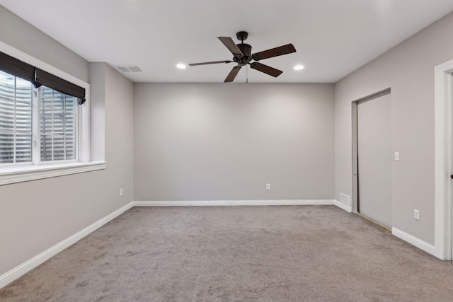 carpeted spare room with ceiling fan