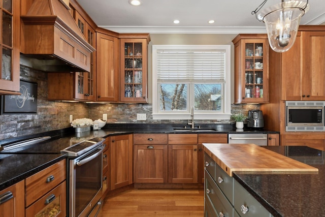 kitchen with sink, decorative backsplash, dark stone counters, and appliances with stainless steel finishes