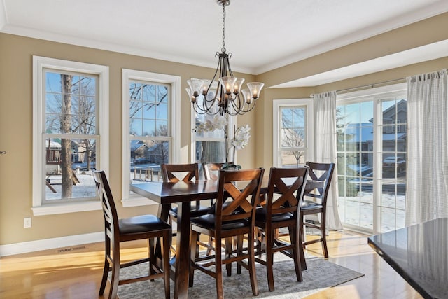 dining space featuring a chandelier and ornamental molding