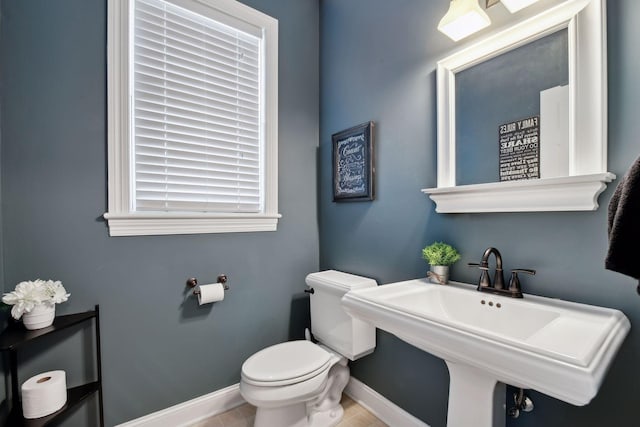 bathroom with sink, plenty of natural light, tile patterned floors, and toilet