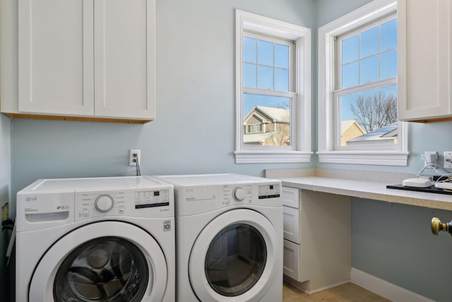 washroom with cabinets and washing machine and clothes dryer