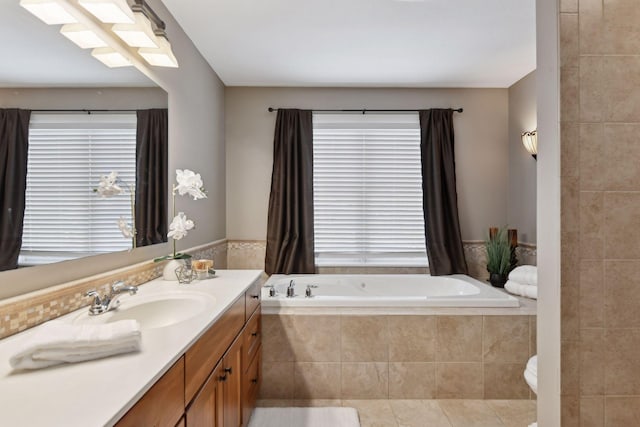 bathroom featuring tile patterned floors, tiled bath, and vanity