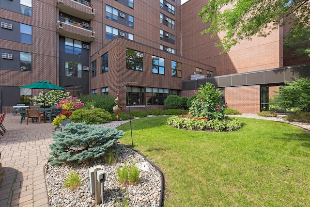 view of property's community with a lawn and a patio