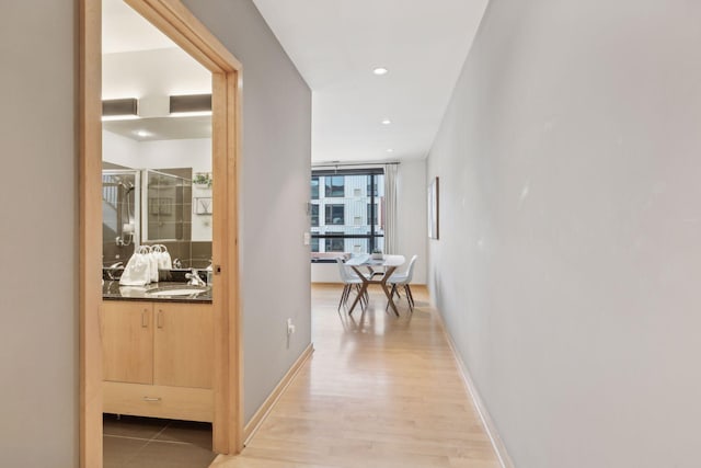 hall featuring wood-type flooring and sink