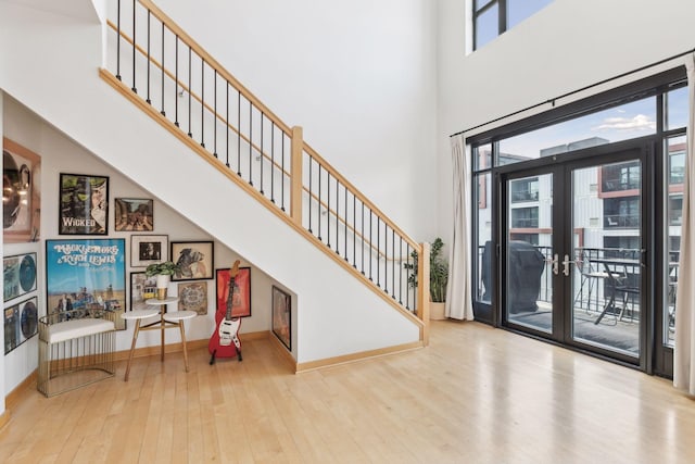 foyer entrance featuring french doors, a high ceiling, and light hardwood / wood-style flooring