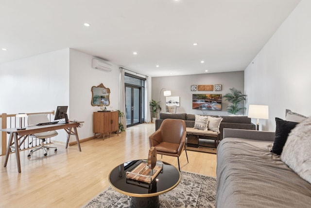 living room with a wall unit AC and light hardwood / wood-style floors