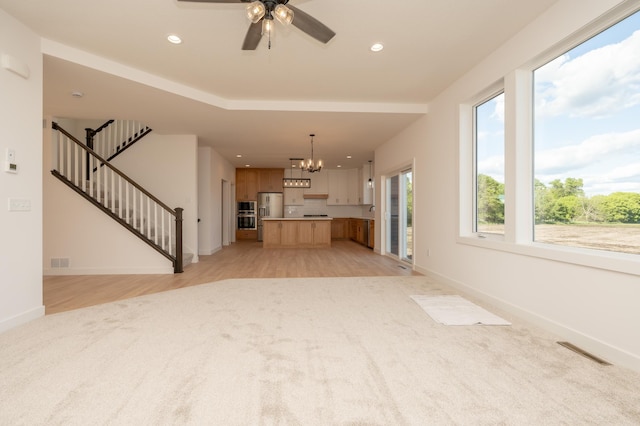 25341 Delmar Ave, New Prague, MN 56071 - unfurnished living room with a chandelier, baseboards, recessed lighting, light wood-type flooring, and a ceiling fan