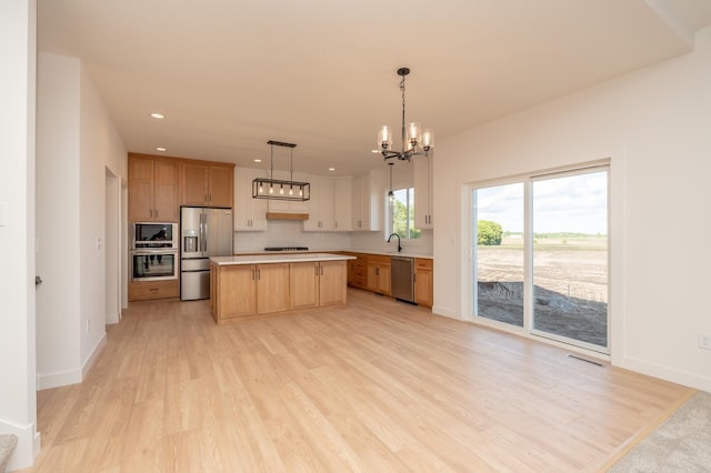 25341 Delmar Ave, New Prague, MN 56071 - kitchen with appliances with stainless steel finishes, a chandelier, light wood finished floors, light countertops, and recessed lighting
