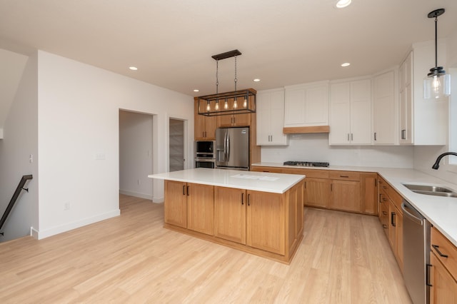 25341 Delmar Ave, New Prague, MN 56071 - kitchen with stainless steel appliances, a sink, light wood-type flooring, light countertops, and a center island