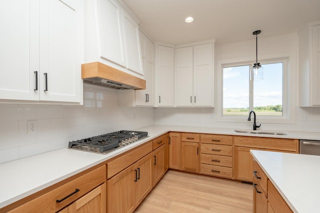 25341 Delmar Ave, New Prague, MN 56071 - kitchen with stainless steel gas cooktop, a sink, decorative backsplash, light countertops, and hanging light fixtures