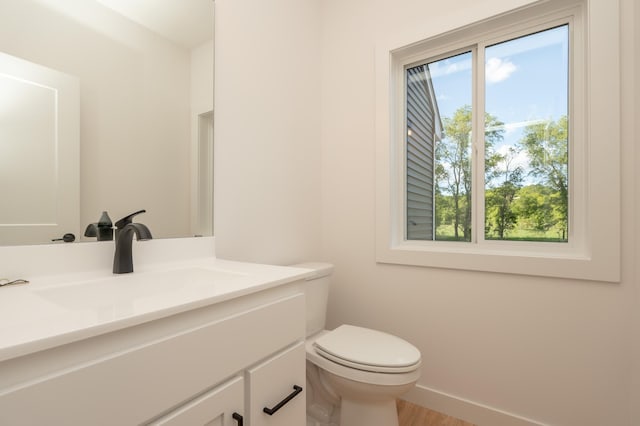 25341 Delmar Ave, New Prague, MN 56071 - bathroom featuring vanity, toilet, wood finished floors, and baseboards