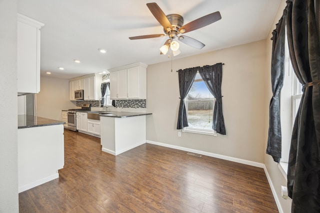 kitchen featuring tasteful backsplash, stainless steel appliances, ceiling fan, dark hardwood / wood-style floors, and white cabinetry