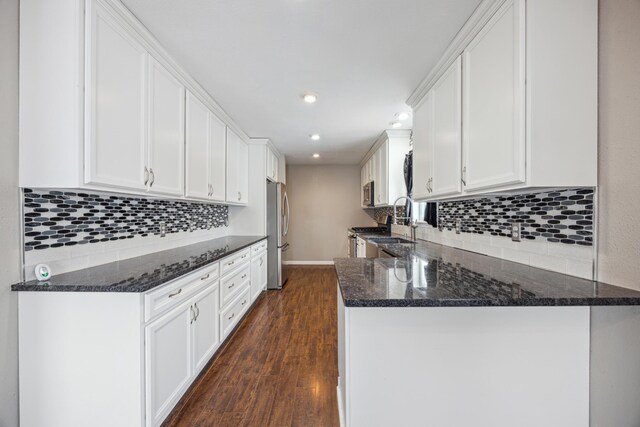 kitchen featuring kitchen peninsula, stainless steel fridge, tasteful backsplash, dark hardwood / wood-style flooring, and white cabinetry