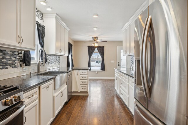 kitchen featuring white cabinetry, dark hardwood / wood-style flooring, kitchen peninsula, decorative backsplash, and appliances with stainless steel finishes