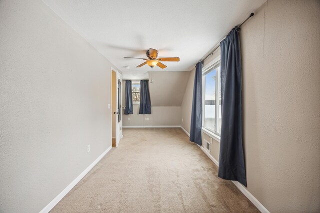 additional living space with light colored carpet, ceiling fan, and lofted ceiling