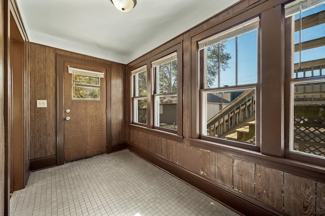 doorway to outside featuring wood walls