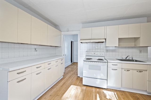 kitchen with backsplash, light hardwood / wood-style floors, white electric stove, and sink