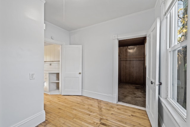 empty room with light wood-type flooring and ornamental molding