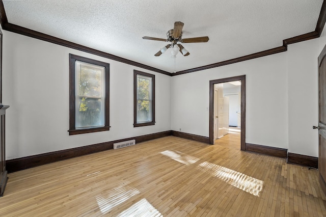 empty room with ceiling fan, light hardwood / wood-style floors, ornamental molding, and a textured ceiling