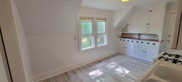 kitchen with light wood-type flooring and white cabinetry