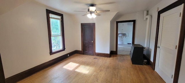 unfurnished bedroom featuring ceiling fan, light hardwood / wood-style flooring, and vaulted ceiling