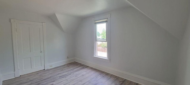 additional living space featuring light hardwood / wood-style floors and lofted ceiling