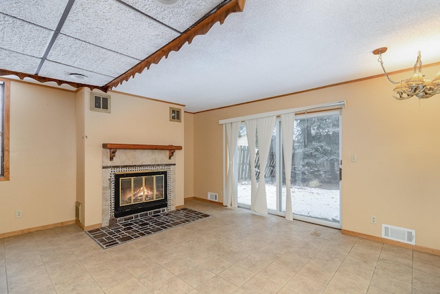 unfurnished living room featuring crown molding, a fireplace, a textured ceiling, and a chandelier