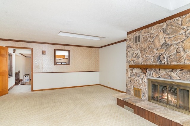 unfurnished living room with ornamental molding, carpet floors, a textured ceiling, and a fireplace