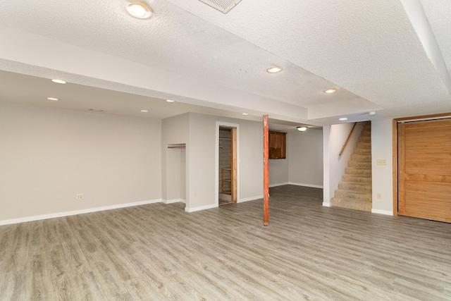 basement with hardwood / wood-style flooring and a textured ceiling